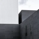 اجرای نمای سیمان آبساب در ساختمان مدرن با بافت تیره و روشن، نمایش سطوح یکدست و خطوط دقیق در طراحی نما